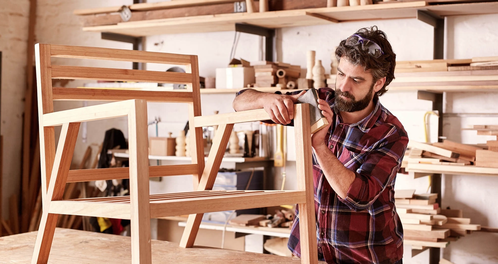 man sanding a wooden chair