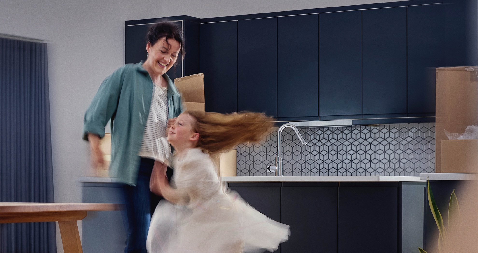Parent and child dancing and celebrating in their home.